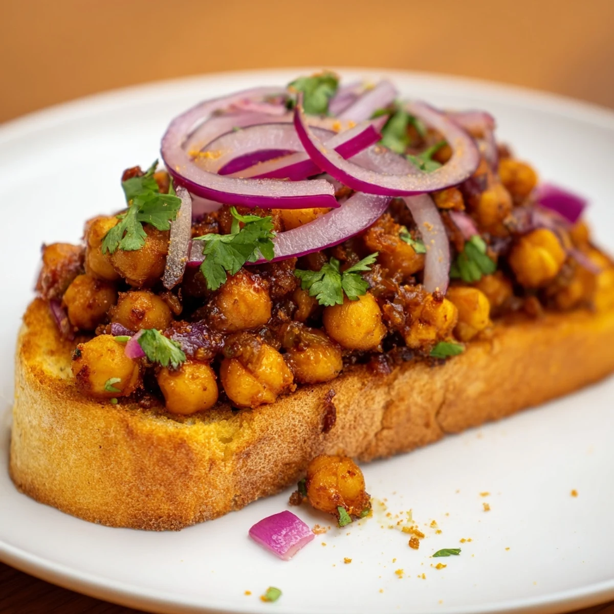 A delicious serving of BBQ chickpeas on toast, garnished with fresh cilantro and red onion.