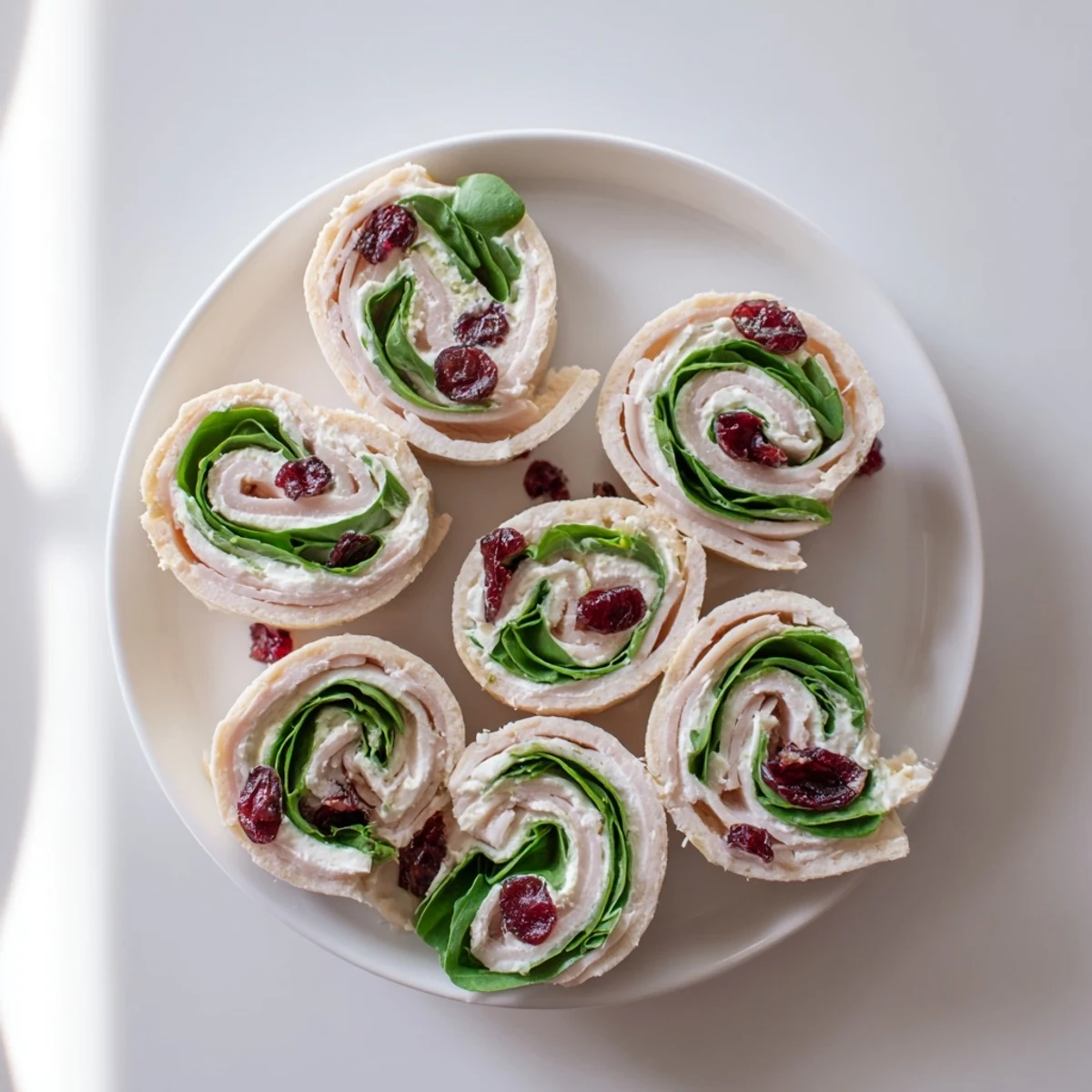 These flavorful Turkey Cranberry Pinwheels are a perfect party appetizer with visible turkey and spinach.