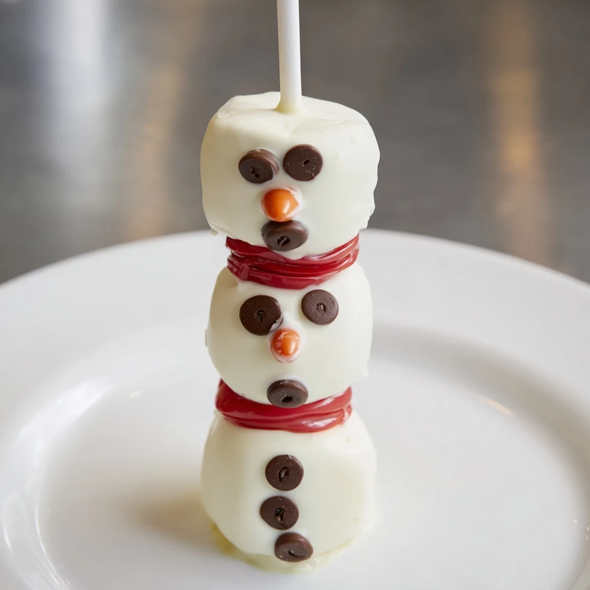 Adorable Express Snowman Marshmallow Pops, adorned with chocolate faces and colorful scarves, look delicious!