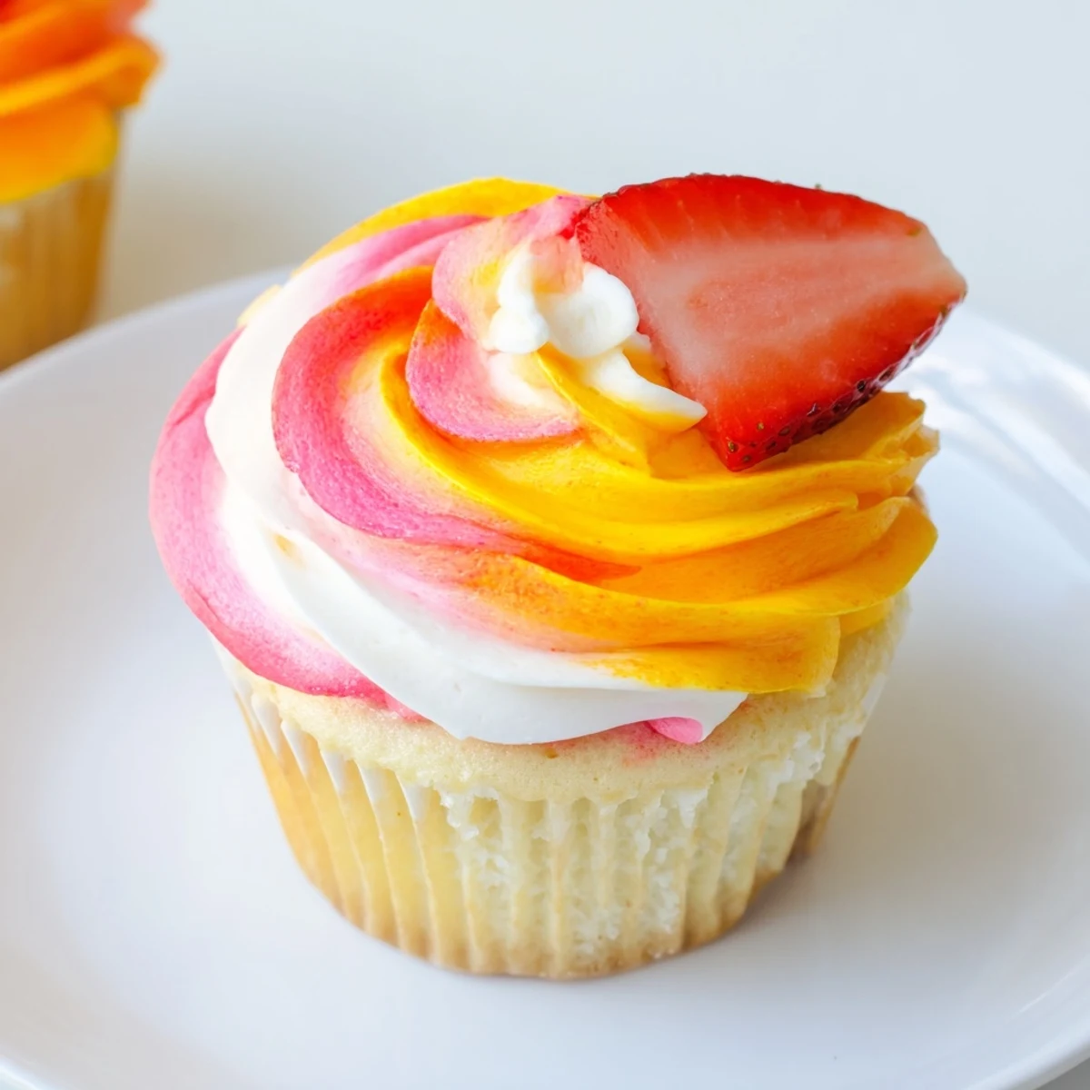 Vibrant Mango Strawberry Sunset Cupcakes, frosted with a sunset swirl, look incredibly delicious and summery.