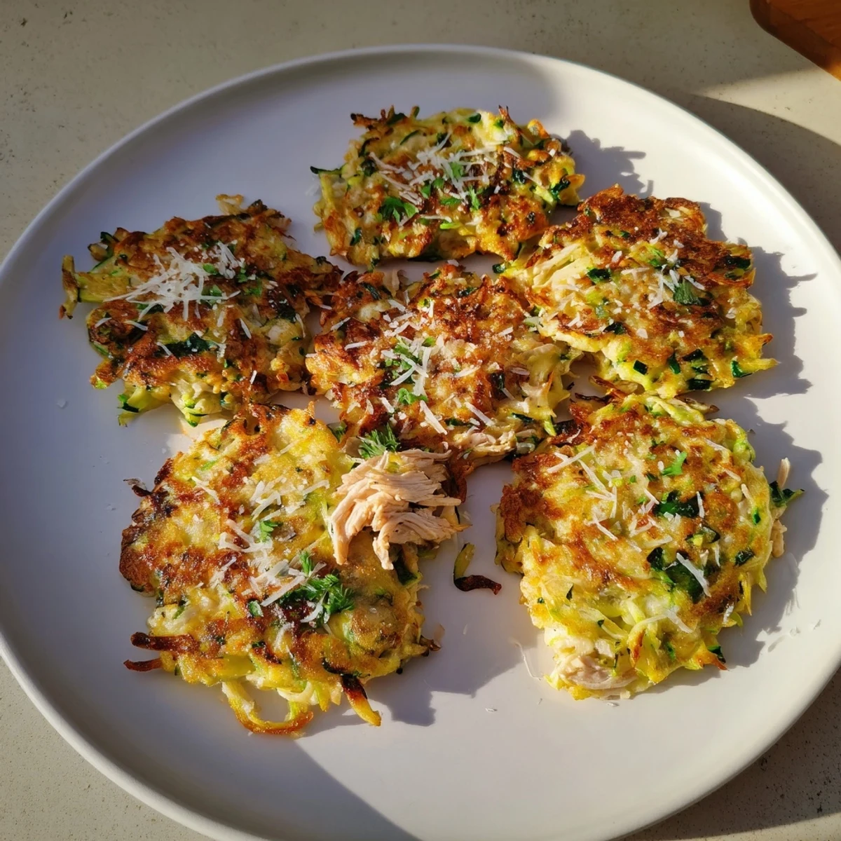Golden-brown high-protein chicken zucchini fritters, perfect for a healthy and satisfying dinner.
