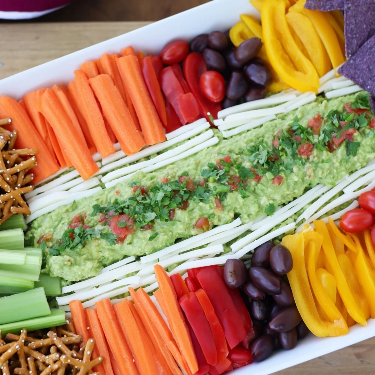 Vibrant game day football field snack board featuring guacamole "turf" and cheese yard lines.