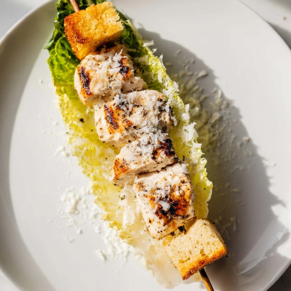 Close-up of Chicken Caesar Salad Skewers: grilled chicken, croutons, and Caesar dressing over fresh romaine.