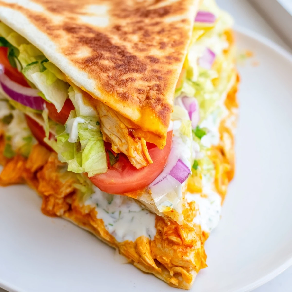 Crispy-seared Buffalo Chicken Wrap filled with creamy ranch, cheddar cheese, and tender chicken, ready to eat!