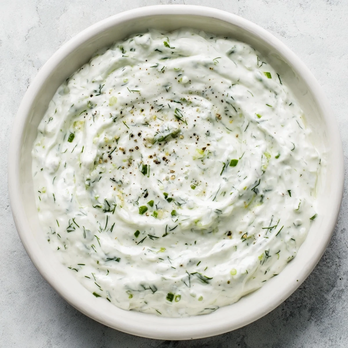 Freshly made Greek Yogurt Ranch Dip, featuring visible flecks of herbs, ready to serve with chips.
