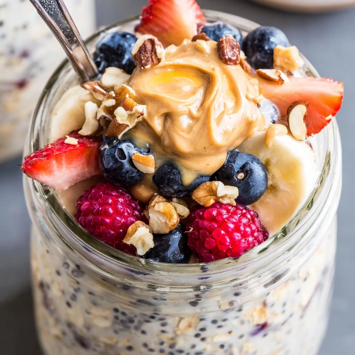 Overnight Oats with Chia Seeds in a clear glass, topped with chopped almonds and a drizzle of honey, ready to enjoy chilled.