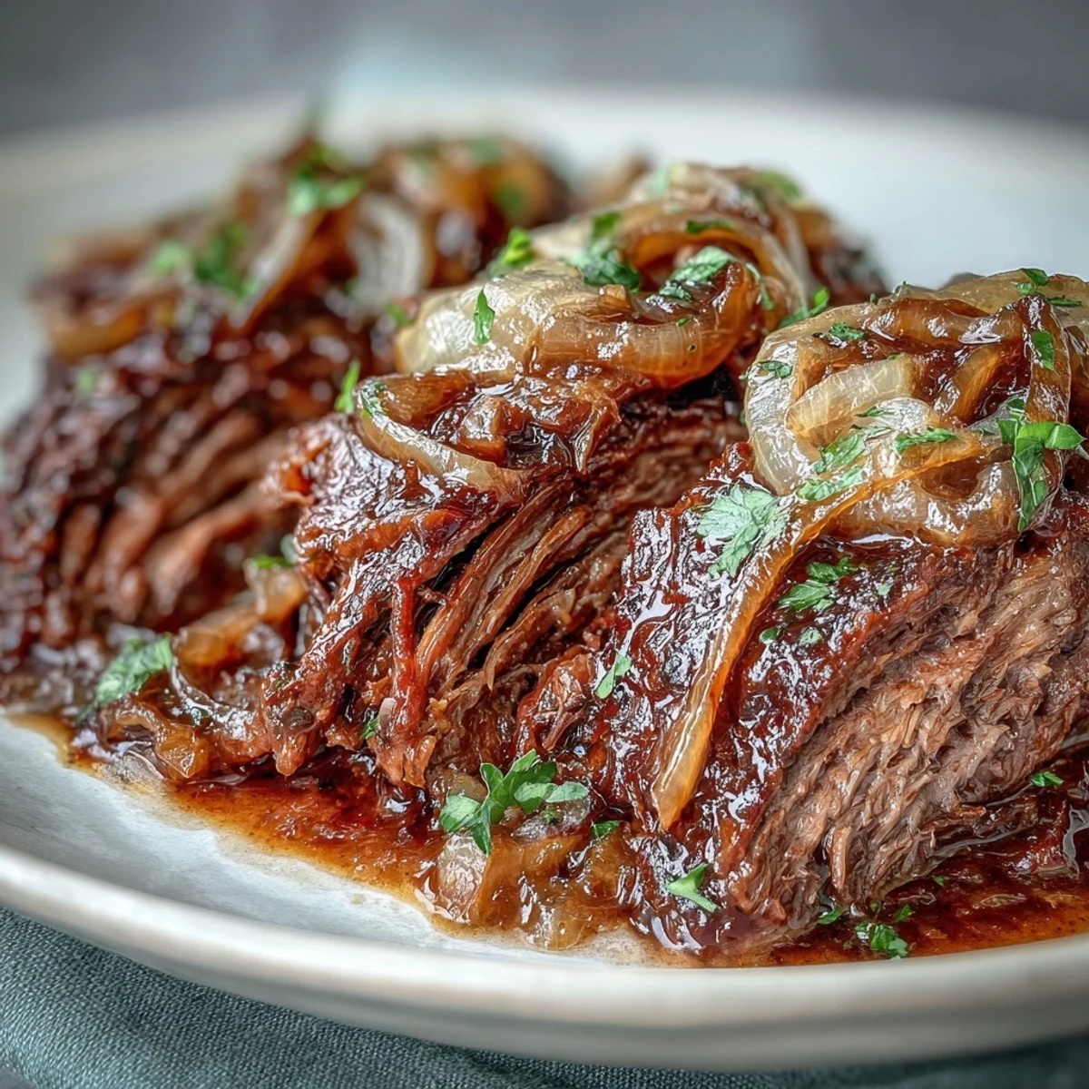 Tender slices of Savory Crock Pot French Onion Pot Roast swimming in rich beef and wine juices, topped with gooey Gruyere.