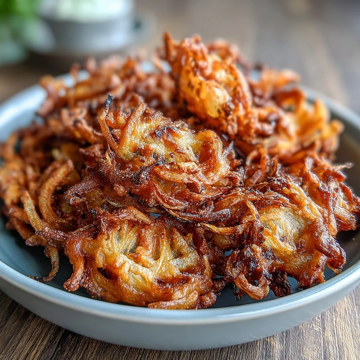Crispy air fryer onion bhajis with golden edges and aromatic Indian spices, perfect for a healthy vegan snack or appetizer.  