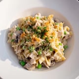 Creamy Tuna Noodle Casserole bubbling from the oven, with tender noodles and vegetables.