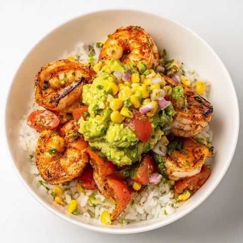 Sizzling grilled shrimp bowl with avocado salsa: a colorful, flavorful summer meal over rice.