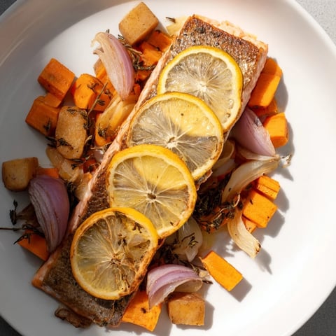 Flaky Sheet-Pan Salmon with root vegetables, glistening with olive oil and lemon slices.