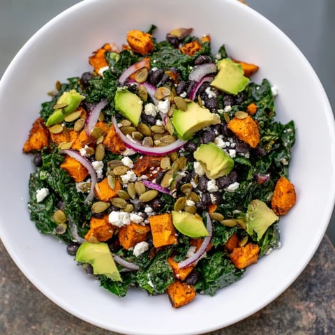 Vibrant massaged kale salad with sweet potato, black beans, and lime dressing, ready to enjoy.