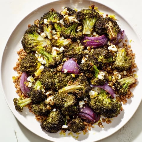 Warm roasted broccoli with a garlic-lemon dressing topping farro, a Mediterranean-inspired dish.