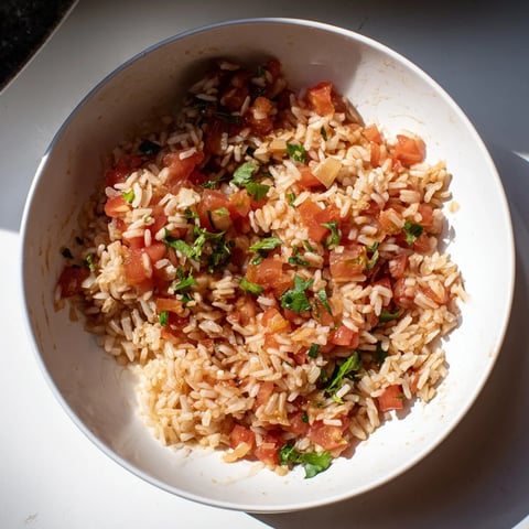 Steaming Tomato-Rice Skillet Dinner, featuring fluffy rice, juicy tomatoes, seasoned to perfection for a quick meal.