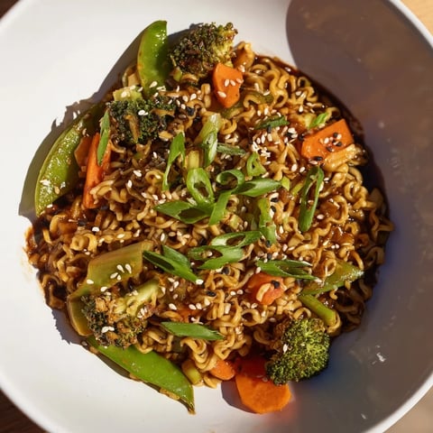 Steaming ramen noodle stir-fry remix with vibrant veggies and a glistening savory sauce.