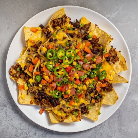 Sheet-Pan Nachos with melted cheese, hearty beans, and colorful frozen veggies, ready to serve.