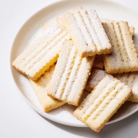 Freshly baked classic shortbread cookies, golden and buttery, ready to enjoy with a cup of tea.