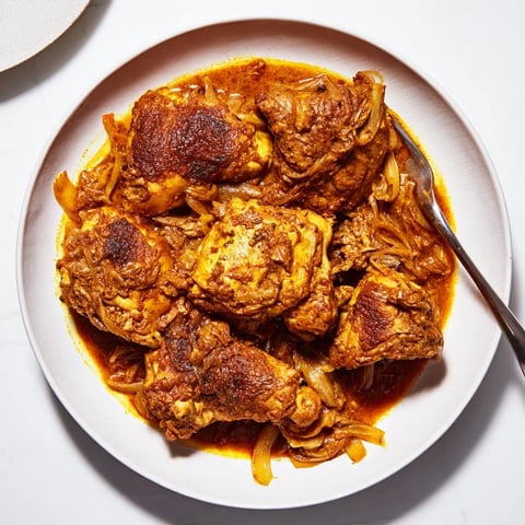 Budget Fesenjan stew simmering, showcasing tender chicken thighs in a rich, dark sauce for a hearty meal.