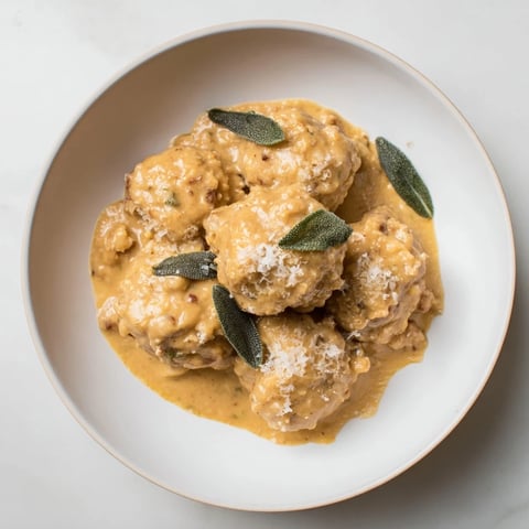 Golden-brown turkey meatballs simmered in a creamy pumpkin sage sauce, ready for dinner.