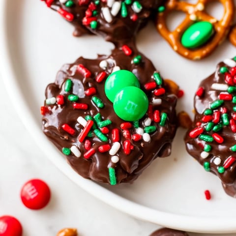 Warm, melted chocolate coats air fryer Christmas pretzel bites, sprinkled with festive red and green holiday colors.