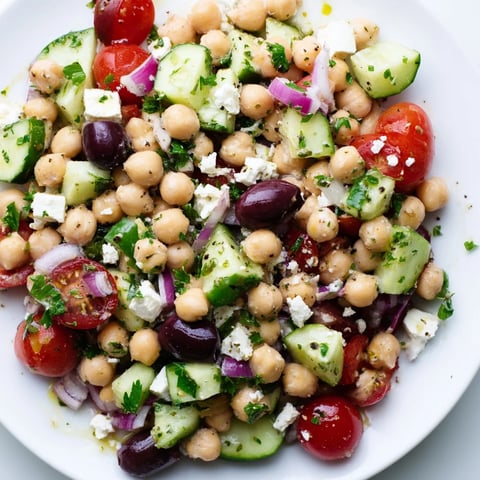 Bright and colorful Mediterranean Chickpea Salad, showcasing fresh tomatoes, olives, and creamy feta cheese.