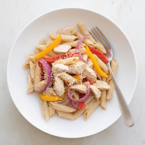 A close-up of Creamy Cajun Chicken Pasta Lite, with juicy chicken strips and al dente penne coated in a spicy, creamy red sauce.