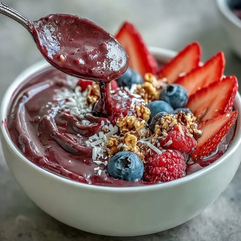 Vibrant Acai Berry Smoothie Bowl bursting with fresh fruit and crunchy granola.
