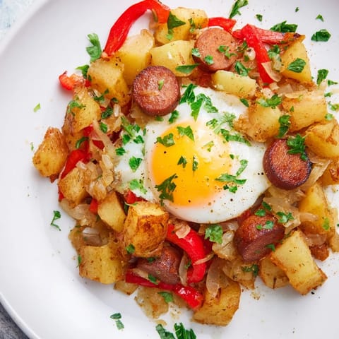 Savory Egg & Potato Hash, a skillet meal with crispy potatoes and sizzling hot dogs, ready to serve.