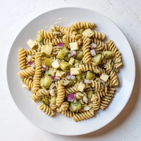 Cool and refreshing dill pickle pasta salad, perfect for a summer picnic or potluck gathering.