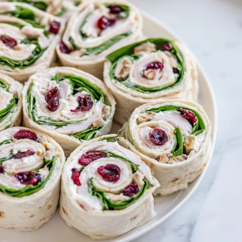 Close-up of freshly made Turkey Cranberry Pinwheels, ready to serve and filled with colorful ingredients.