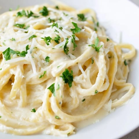 Fresh parsley garnish on a homemade Pasta Alfredo Cottage Hack, a lighter, easy Italian dish.