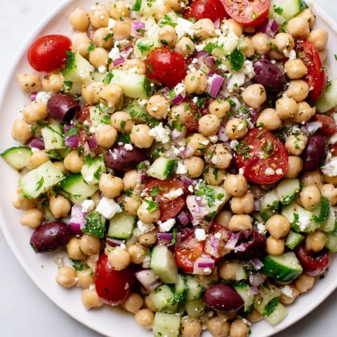 Freshly tossed Mediterranean Chickpea Salad with a vibrant lemon dressing, ready for serving or chilling.