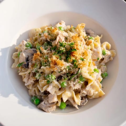 Creamy Tuna Noodle Casserole bubbling from the oven, with tender noodles and vegetables.