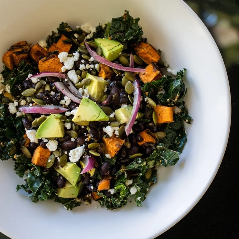 Hearty massaged kale salad with black beans, roasted sweet potato, and avocado, fresh and delicious.