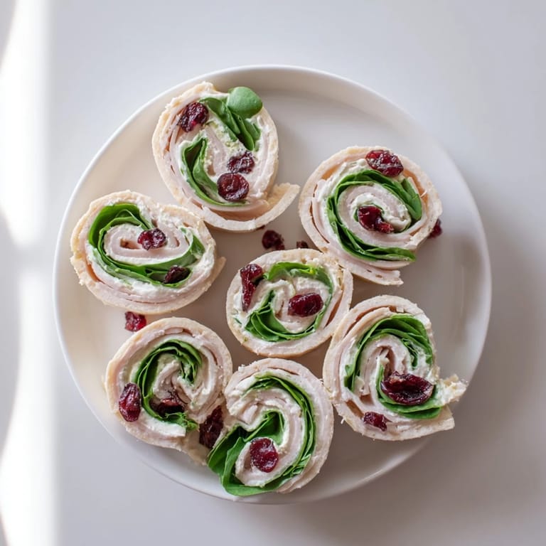 These flavorful Turkey Cranberry Pinwheels are a perfect party appetizer with visible turkey and spinach.