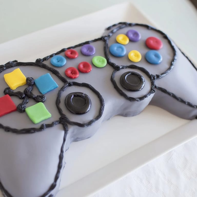Enjoy a slice of homemade Pixel Perfect Video Game Controller Board cake, a fun dessert for gamers of all ages.