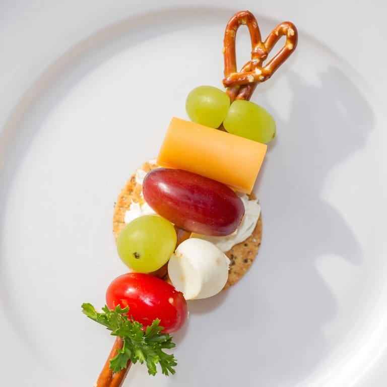 Picture these whimsical Up, Up, & Away Hot Air Balloon Snacks; cheese, grapes, and tomatoes in a fun party arrangement.