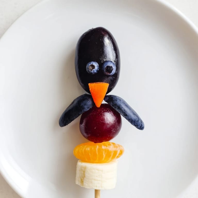 Adorable Penguin Fruit Skewers are ready to be eaten, showcasing colorful fruit arranged as friendly penguins.