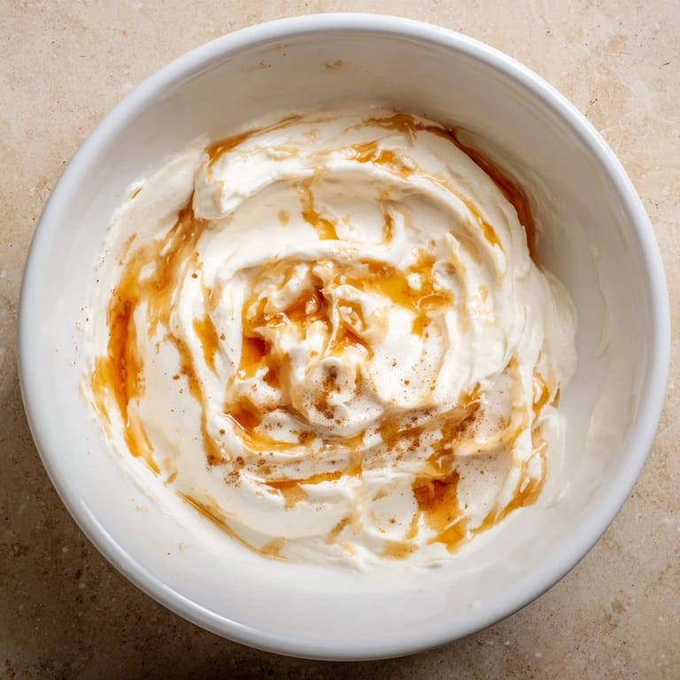 Tangy Greek yogurt fruit dip, swirled with honey, and served with a colorful fruit platter.