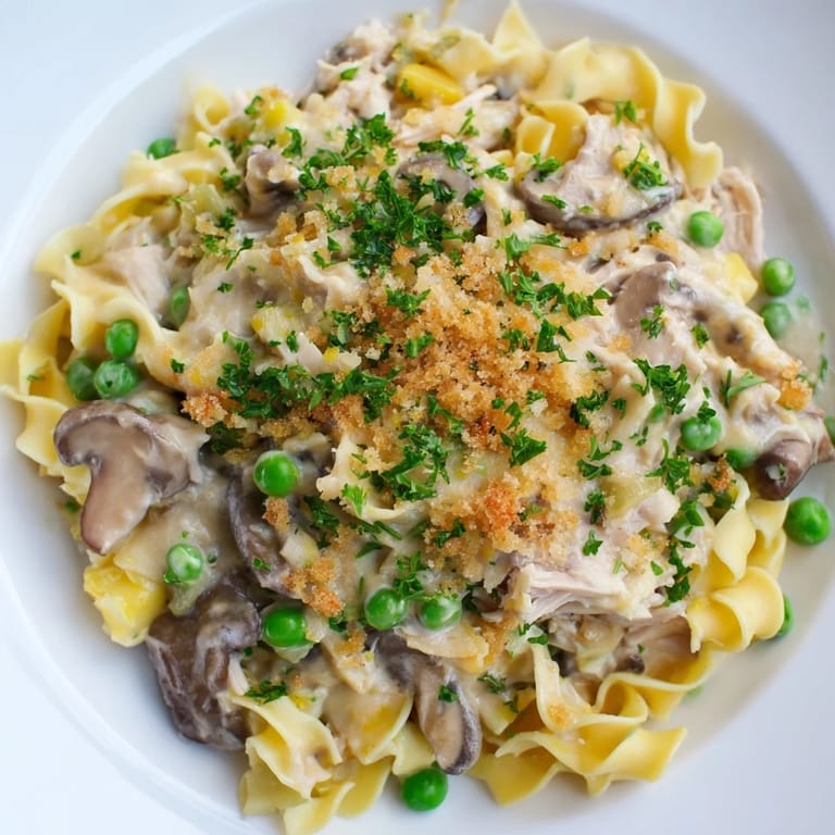 Close-up shot shows a comforting bowl of Tuna Noodle Casserole, a classic American dish.
