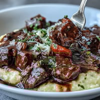 Creamy polenta topped with rich venison stew with Sloe Gin, slow-simmered with aromatic herbs and vegetables.