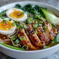 Steaming Healthy Miso Chicken Noodle Bowls feature sliced chicken and soba noodles in a rich, savory broth with bok choy.