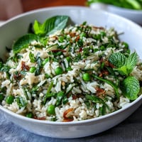 A vibrant bowl of spring pea and mint rice pilaf, with bright green peas and fresh herbs, perfect for Easter or spring dinners.