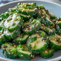 A vibrant Asian cucumber salad with sesame and rice vinegar dressing, crisp and tangy for a refreshing bite.