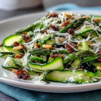 Shaved asparagus salad with lemon and Parmesan, fresh ribbons tossed in citrus dressing and topped with cheese.